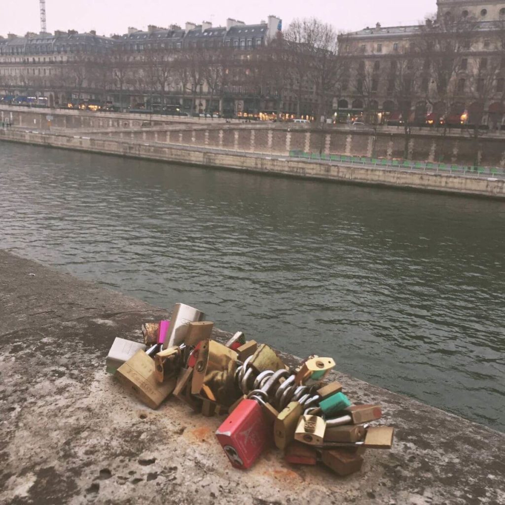 Closeup of dozens of locks attached to a handrail next to the Ponts des Arts in Paris, France.