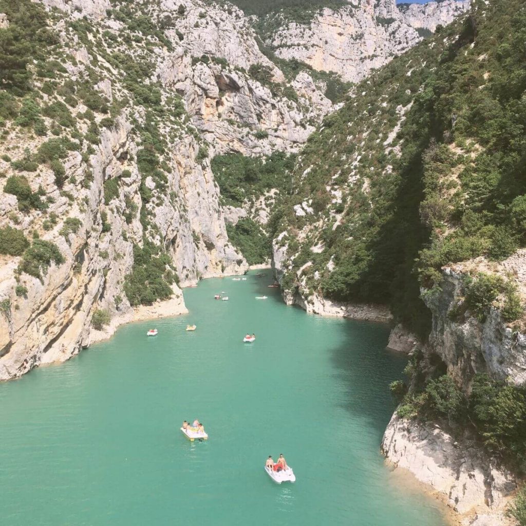 Aerial photo of Verdon Gorge in France with several people on paddle boats in the water.