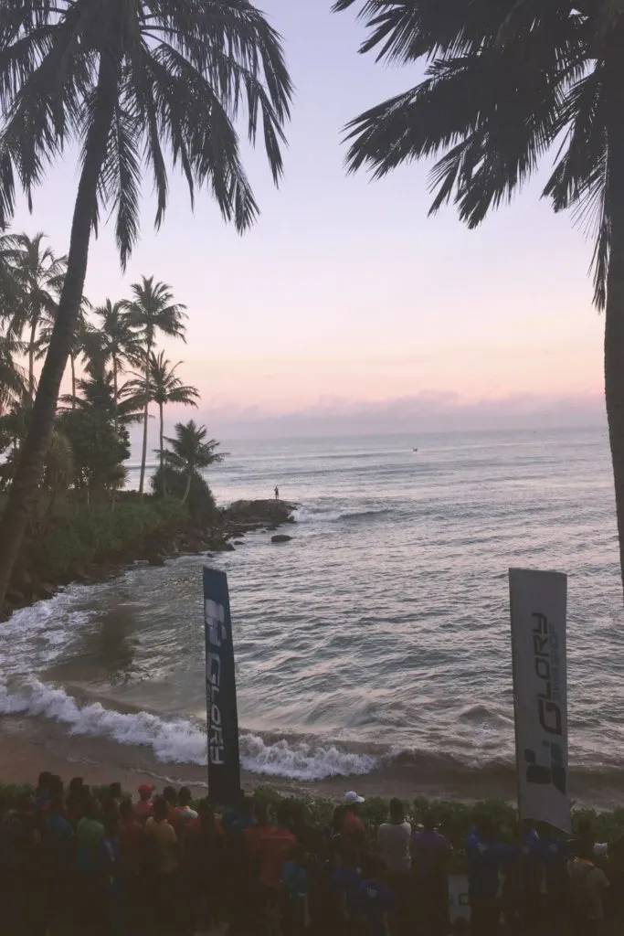 Photo of the beach outside Mount Livinia Hotel in Sri Lanka with crowds watching a swim competition.