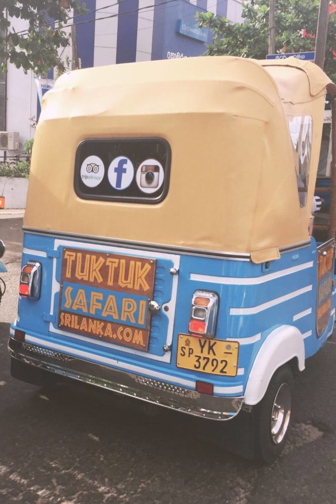 Photo of a bright blue and yellow tuk tuk with a sign that says "TukTuk Safari Sri Lanka."