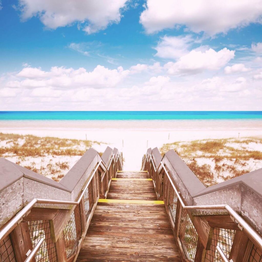 Photo looking down a wooden stairwell leading to Henderson Beach State Park in Destin, FL.