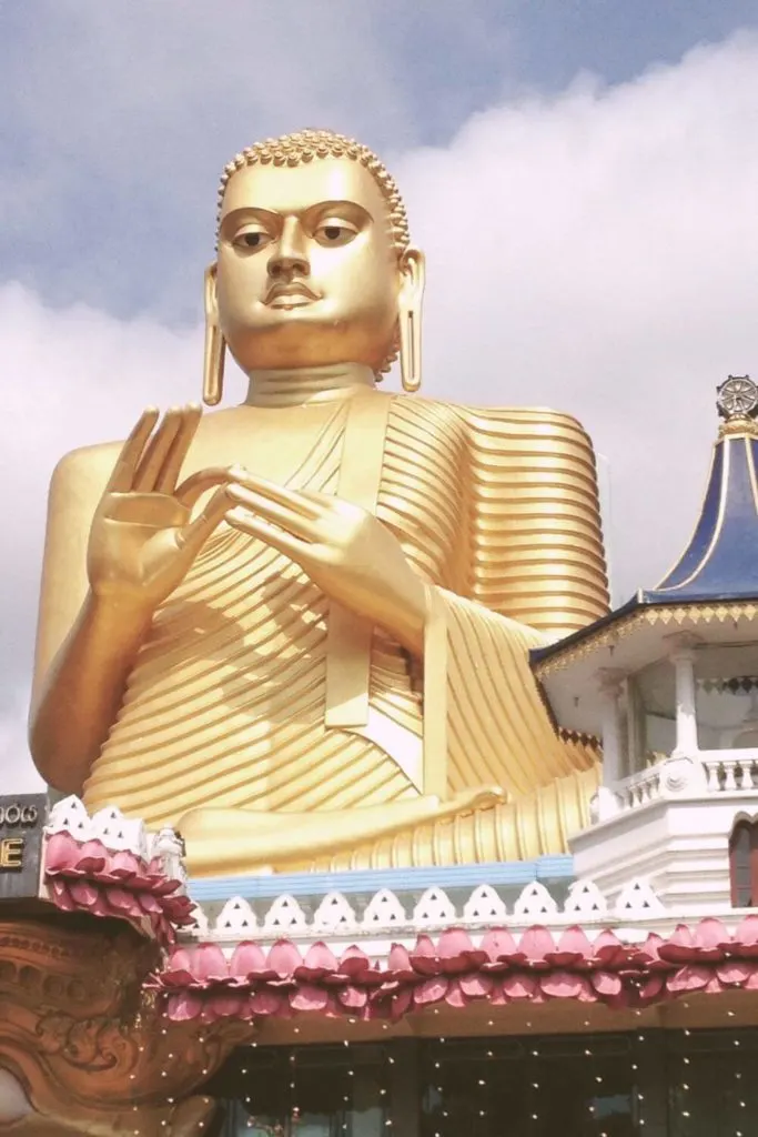 Closeup photo of a large golden Buddha statue at Dambulla Cave Temple.