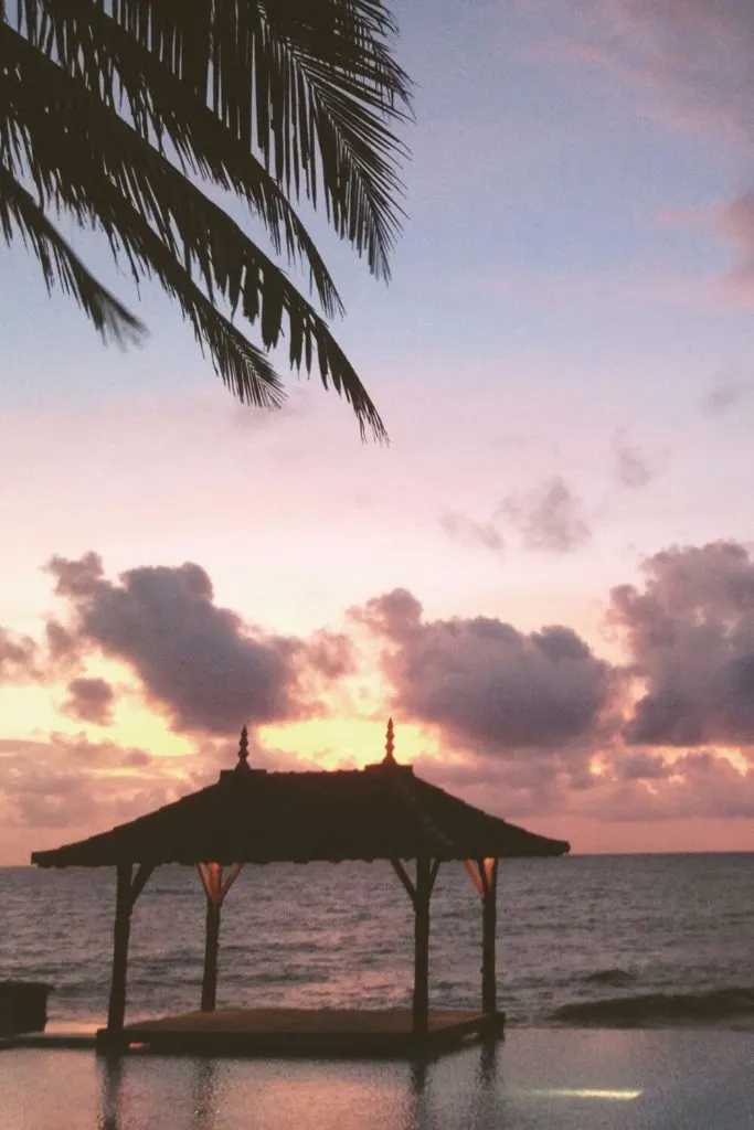 Photo of a resort pool with a pagoda overlooking the Indian Ocean in Sri Lanka during sunset.