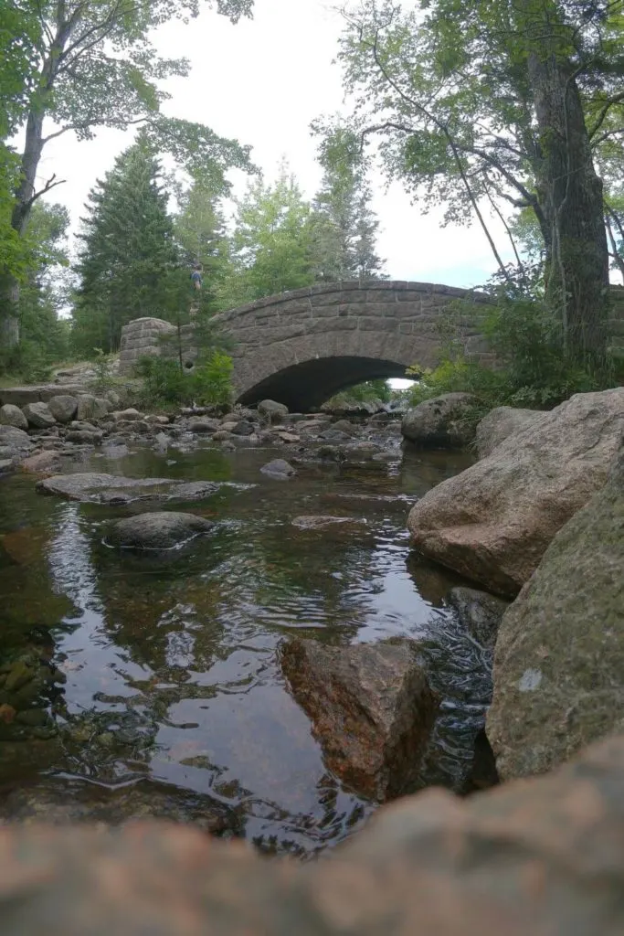 Photo of the Jordan Pond Dam Bridge with a stream in the foreground.