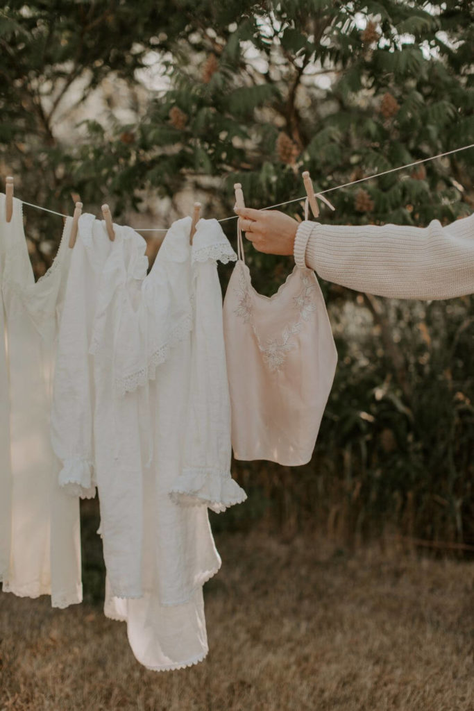 Photo of feminine, boho clothing hanging on a drying rack outside.