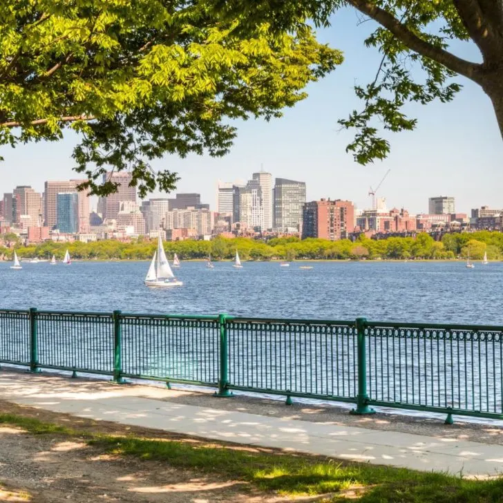Photo of the walkway along the Charles River in the Spring with sailboats in the river.