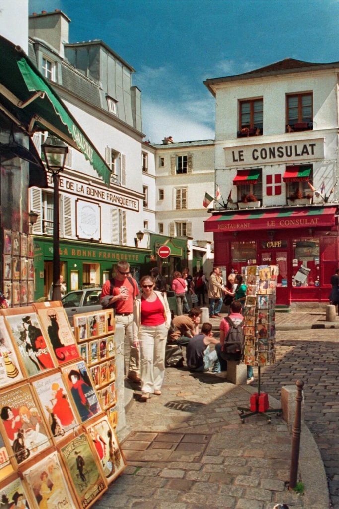 Photo of a cobblestone square in Montmartre, with Le Consulat Café in the background.