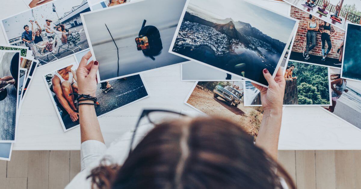 Photo from top down of a person sorting through photo prints.