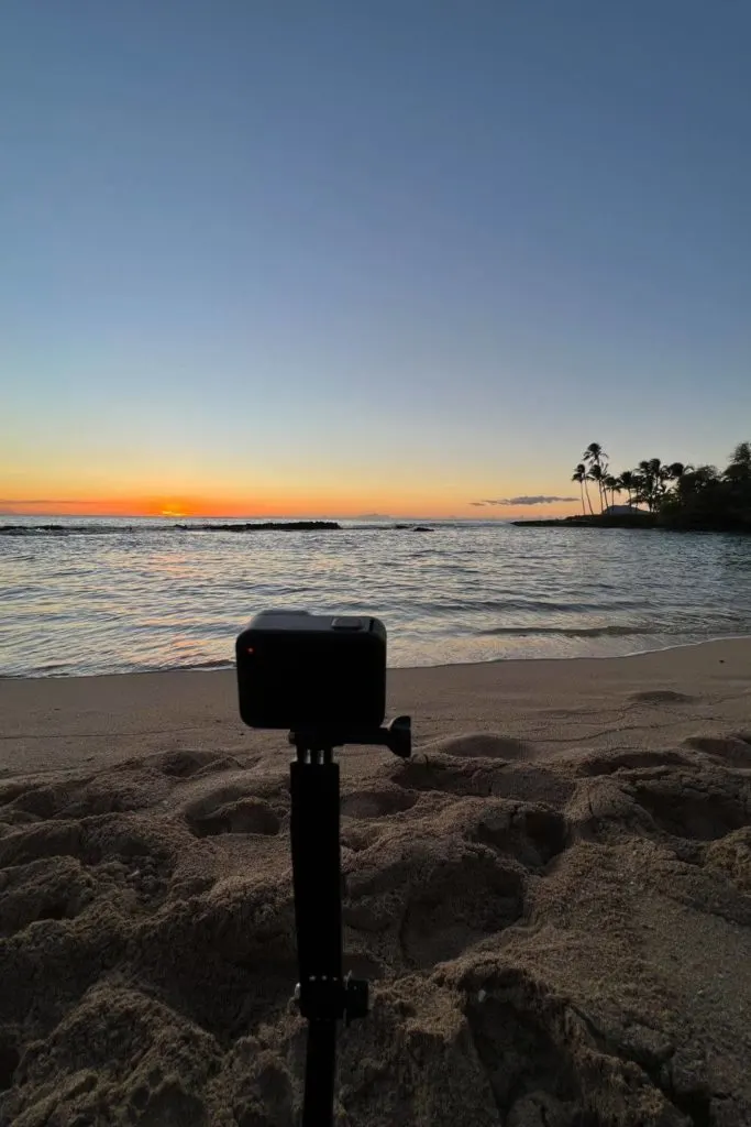Photo of a GoPro camera stuck in the sand, taking video of the sunset in Kapolei, Oahu.
