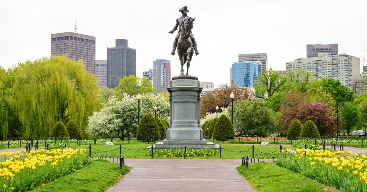 Photo of the Paul Revere Statue in the Boston Public Garden with tulips in the foreground.