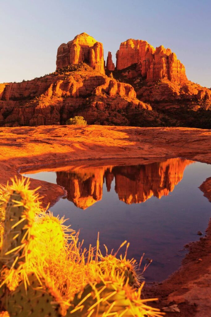 Photo of Cathedral Rock in Sedona, Arizona, with the rock reflecting in some water.