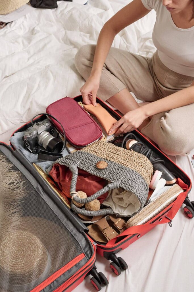 Photo of a woman packing a small suitcase with Spring accessories.